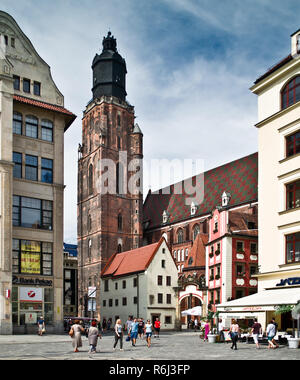 WROCLAW Polen - 18. August 2013: Der Hl. Elisabeth Kirche ist hinter den Häusern der alten Odrzanska Straße neben dem Marktplatz im August ausgeblendet Stockfoto