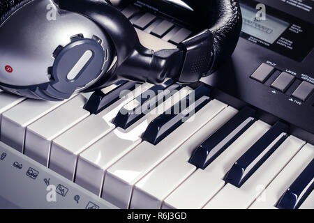 Kopfhörer liegen oben auf einem Synthesizer Stockfoto