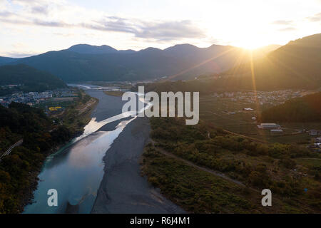 Sonnenuntergang über der Landschaft Landschaft von einem Fluss, Drone, Japan Stockfoto