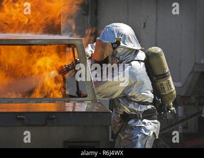 Marines mit Marine Wing Support Squadron (MWSS) 373, Expeditionary Feuer und Rettung (EFR), simulierten car Fire Training während der integrierte Ausbildung Übung (ITX) 3-17, auf einer strategischen Expeditionary Landeplatz, an der Marine Corps Air Ground Combat Center Twentynine Palms, Calif., 19. Mai durchführen. ITX ist eine kombinierte Waffen übung Marines ermöglicht über 3. Marine Flugzeugflügel als Aviation combat Element mit Boden und Logistik Kampf als Marine Air-task force integriert zu betreiben. Mehr als 650 Marines und 27 Flugzeuge mit 3 MAW unterstützen ITX 3-17. Stockfoto