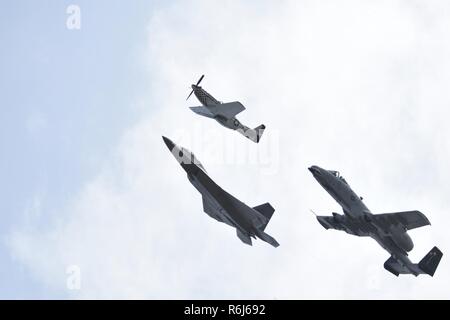 Eine P-51 D Mustang, F-22 Raptor und A-10 Thunderbolt eine Hommage Flug während der Flügel über Wayne Air Show, 21. Mai 2017, bei Seymour Johnson Air Force Base, North Carolina. Die Bildung bestand von Flugzeugen aus dem zweiten Weltkrieg zu aktuellen 5. Generation von Flugzeugen. Stockfoto