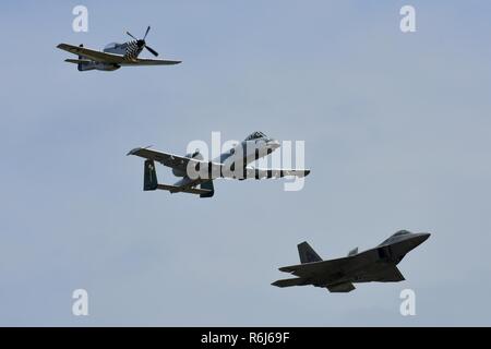 Eine P-51 D Mustang, A-10 Thunderbolt und F-22 Raptor ein Tribut Flug während der Flügel über Wayne Air Show, 21. Mai 2017, bei Seymour Johnson Air Force Base, North Carolina. Die Bildung bestand von Flugzeugen aus dem zweiten Weltkrieg zu aktuellen 5. Generation von Flugzeugen. Stockfoto