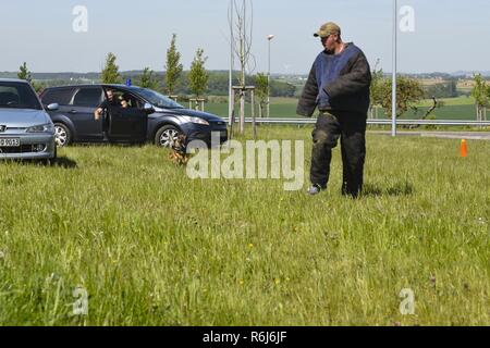 Us Air Force Staff Sgt. Tyler Catey, 52 Sicherheitskräfte Squadron Militär Hundetrainer und Luxemburg Polizisten, Hund nehmen, zeigen die Techniken zu Spangdahlem Grundschüler in Spangdahlem Air Base, Germany, 16. Mai 2017. Diese Veranstaltung war Teil der US-amerikanischen Nationalen Polizei Woche, der die Männer, Frauen und ihre vierbeinigen Gefährten, die das Abzeichen tragen. Stockfoto