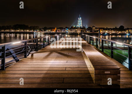 Bei Nacht mit Blick von einem Steg Deventer über die Ijssel. Der Turm der Kirche ist vor der Lebuinus wunderschön beleuchtet Stadtbild überragt. Stockfoto