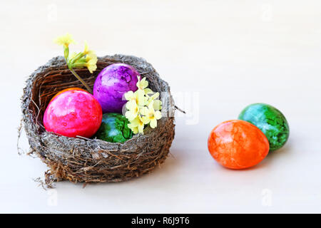 Ein Ostern Korb mit bunten Ostereier auf einem hellen Hintergrund Stockfoto