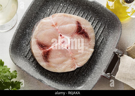 Rohen Schwertfisch Steak auf dem Grill Pfanne mit Olivenöl und Gewürzen, Weißwein Glas Stockfoto