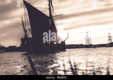 Silhouette der historischen Segelboote auf der Flüsse der Niederlande. Der Abend fällt in und in einer stimmungsvollen Sommerabend die Boote segeln über die w Stockfoto
