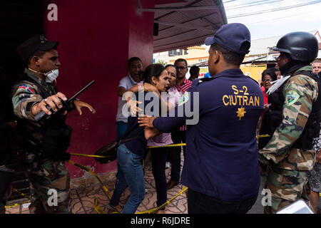 Santo Domingo, Dominikanische Republik. 05 Dez, 2018. Bewohner aus einem Kunststoff Fabrik mit Sicherheitskräften diskutieren nach einer starken Explosion. Der Schock in der Fabrik zerstört die umliegenden Häuser und, nach Angaben der Zeitung, war in großen Teilen der Stadt zu spüren. Die Ursache der Explosion ist noch unklar. Credit: Pedro Bazil/dpa/Alamy leben Nachrichten Stockfoto