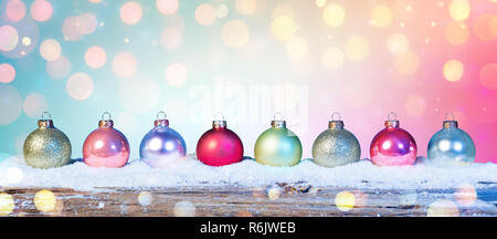 Bunte Kugeln auf Schnee In glänzenden Hintergrund Stockfoto