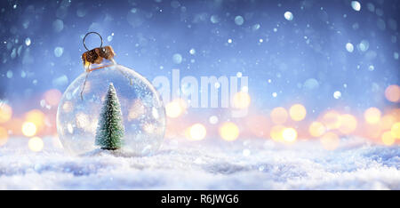 Snow Ball mit Weihnachtsbaum und Lichter auf Winter Hintergrund Stockfoto