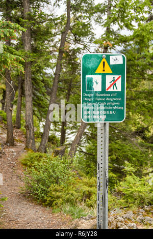 BANFF, Alberta, Kanada - Mai 2018: Neben einem Wanderweg in Banff Warnung Besucher für eine gefährliche Klippe unterzeichnen. Stockfoto