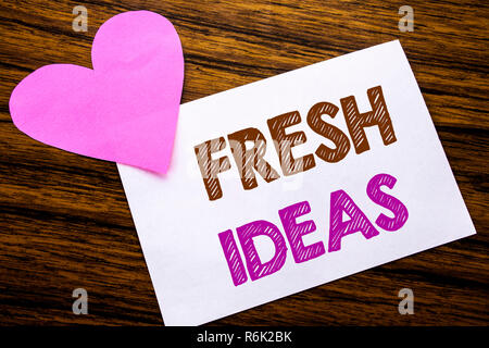 Konzeptionelle Hand Schreiben von Text mit frischen Ideen. Konzept für das Denken Inspiration Inspiration Kreativität auf haftnotiz Papier, Holz Holz Hintergrund. Mit rosa Herz bedeutet Liebe Anbetung. Stockfoto