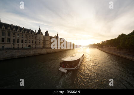 Touristische Bootsfahrt auf der Seine Fluss mit schönen Sonnenuntergang in Paris. Kreuzfahrtschiff Sehenswürdigkeiten entlang des Flusses in Paris, Frankreich. Stockfoto