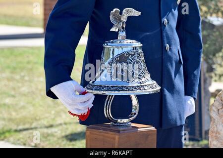 Eine gemeinsame Basis Color Guard Mitglied eine Glocke schellt beim Departement für Verteidigung gefallenen Firefighter Memorial auf Goodfellow Air Force Base, Texas, 12. Mai 2017. Die Glocke ist Rang vier Ringe, fünf Mal, markiert das Ende der Uhr für die Feuerwehrmänner. Stockfoto