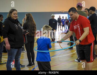 Us Air Force Tech. Sgt. Jonathan Garrett, 86th Fahrzeug Bereitschaft Squadron Ressource Advisor, hilft, Kai, ein spezieller Olympier, Praxis für die Hula Hoop Ereignis auf der Air Base Ramstein, Deutschland, 19. Mai 2017. Die Hula Hoop Veranstaltung war nur eine von mehreren Wettbewerben während der 2017 Frühling Kaiserslautern Military Community Special Olympics statt. Mehr als 70 Studenten in Veranstaltungen wie Hula Hoop, Tauziehen, Basketball, Volleyball und vieles mehr den ganzen Tag konkurrierten. Stockfoto