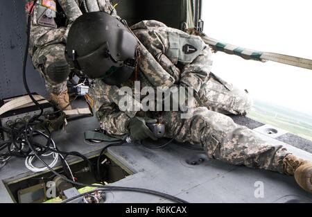 U.S. Army Staff Sgt. Cassandra Kennedy, ein Flug der Sanitäter zu multinationalen Battle Group-East's Southern Command Post zugeordnet beobachtet und drückt das Ventil Entriegelungstaste auf einem Wassereimer zu einem UH-60 Black Hawk Hubschrauber während einer Übung in Dakovica, Kosovo, 22. Mai beigefügt. MNBG-Osten der Südlichen Post-Befehl durchgeführt Wassereimer Training mit Ihren aviation Crew Mitglieder, um die Mission der Army National Guard von Brandschutz und Katastrophenschutz zu unterstützen. Stockfoto