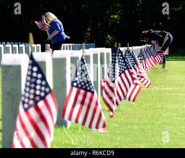 Meagan Wallace (rechts), eine Studentin an Cabot High School, Orte Flags in der Nähe von grabsteinen an der Arkansas State Veteran-kirchhof in North Little Rock, Arche während der 2017 Memorial Day Flag Placement Ereignis am 24. Mai statt. Ihrem Stiefbruder, Sgt. William Moody, wurde in der Tätigkeit bei einem Mörserangriff am 18. Juni 2013 getötet, während in Afghanistan zur Unterstützung der Operation Enduring Freedom. Stockfoto