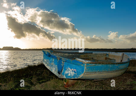 Landschaft Foto von einem Feuchtgebiet vorland unter einem dramatischen Himmel mit verfallenen Holzboot im Vordergrund. Stockfoto