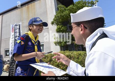 SHIMODA, Japan (20. Mai 2017) Quartermaster Seaman Apprentice Dylon Sisson, in die Vorwärts-Einsatz geführte Anti-raketen-Zerstörer USS Mustin (DDG89), gibt ein zu einem jungen japanischen cub Scout bei der 78Th Shimoda schwarzen Schiff Festival Autogramm. Die Beteiligung der Marine in den Festival feiert das Erbe der US-Japanischen Marine Partnerschaft Erste von Commodore Matthew Perry 1853 Ankunft in Japan gegründet. Seit mehr als 160 Jahren, in den Vereinigten Staaten hat ein Erbe des militärischen Präsenz in der Indo-Asia-Pazifik-Region zu fördern, Wohlstand und Sicherheit im Seeverkehr etabliert. Stockfoto