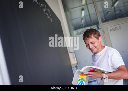 Hübsche Studentin eine mathematisches Problem zu lösen, während der Math-Klasse vor der Tafel/Tafel (getönten Farbbild) Stockfoto
