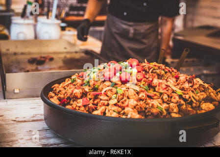 City street Kochen in Europa. Street Food. Koch bereitet große Platte von Fleisch. Stockfoto