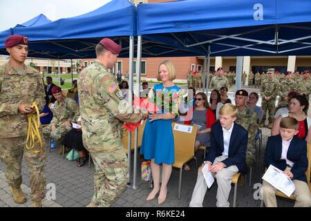 Oberstleutnant Michael F. Kloepper, ausgehende Kommandant der zweiten Bataillon, 503Rd Infanterie Regiment, 173Rd Airborne Brigade, gibt einen Strauß roter Rosen zu seiner Frau Ellen Kloepper, während der Befehl Zeremonie an Caserma Del Din in Vicenza, Italien, 24. Mai 2017. Die 173Rd Airborne Brigade, in Vicenza, Italien, ist die Armee Contingency Response Force in Europa, und ist in der Lage, Kräfte projizieren die vollständige Palette der militärischen Operationen in den Vereinigten Staaten der Europäischen, Zentralen und Afrika Befehle Verantwortungsbereiche zu führen. Stockfoto