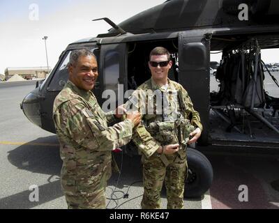 Generalleutnant Michael Garrett, der kommandierende General der US-Army Central, präsentiert 1. Lt. Benjamin Gonzalez, der Zugführer für eine Firma, 2. Allgemeine Unterstützung Aviation Battalion, 149 Aviation Regiment, mit seiner Bekämpfung Pflaster in einem improvisierten Combat patch Zeremonie auf dem Hubschrauberlandeplatz, auf Ali Al Salem Air Base, Mai 20. Gonzalez organisiert die überraschung Combat patch Zeremonie für die neue Crew Chiefs. Stockfoto