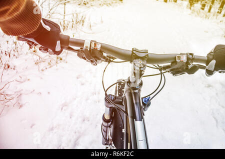 First Person Sicht der Radfahrer in den Winterwald. Wnter Mountainbike Konzept Stockfoto
