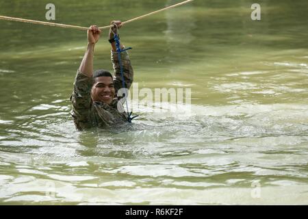 Us-Armee Sgt. Stiven Cedeno, auf die 1 Battalion, 506Th Infantry Regiment, 1st Brigade Combat Team, 101St Airborne Infanterie Division, benutzt ein Seil ein Fluß während United Accord 2017 Jungle Warfare School auf Achiase Militärbasis in Akim Oda, Ghana am 22. Mai 2017 zu überqueren. Die Jungle Warfare School ist eine Reihe von situativen Übungen entwickelt, die Teilnehmer in die Train-Aufstand und die innere Sicherheit. Stockfoto