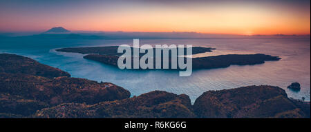 Sonnenuntergang Panorama rview Indonesiens Küste und das Meer. Antenne drone Schuß des Asiatischen wilde Natur. Atemberaubende Landschaft. Sonnenuntergang über der Indonesischen land und ruhigen Meer. Leuchtend bunte Himmel. Stockfoto