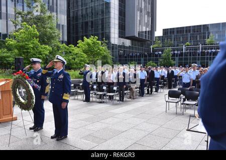 Master Chief Petty Officer der Küstenwache Steven Cantrell und Küstenwache Kommandant Adm. Paul Zukunft grüßt einen Kranz vor einem Bild der Coast Guard Cutter Tampa und Crew während des Memorial Day Einhaltung an der Douglas A. Munro Coast Guard-Hauptquartier in Washington, D.C., 26. Mai 2017 gestellt. Der Cutter Tampa war torpediert, nachdem er einen Konvoi nach Wales in 1918, was zu einem Verlust der alle 131 Menschen an Bord. Us-Küstenwache Stockfoto