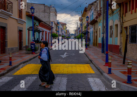 COTACACHI, Ecuador, November 06, 2018: unbekannte Menschen zu Fuß und Überqueren der Straßen in einem kolonialen Stadt Gebäude in der Stadt Cotacac entfernt Stockfoto