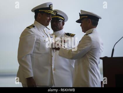 Hintere Adm. Harry Harris, US Pacific Command Commander, präsentiert Kapitän Stephan Newlund, Kommandant der Patrouille und Aufklärung Flügel zwei, mit der Legion of Merit Award während der Patrol Wing Squadron Auflösung Zeremonie im Hangar 105 an Bord der Marine Corps Air Station Kaneohe Bay am 24. Mai 2017. Nach 80 Jahren auf Oahu, Flügel zwei wurde aufgelöst und die Flügel 10 Neu auf der Naval Air Station Whidbey Island, Washington stationiert. Stockfoto