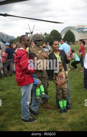 Besucher pose mit einem Marine am Eisenhower Park, N.Y., bei der Fleet Week New York 2017, 27. Mai 2017. Marines, Matrosen und Küstenwache sind in New York mit der Öffentlichkeit zu kommunizieren, sich Fähigkeiten demonstrieren und die Leute von New York über America's Meer Dienstleistungen unterrichten. Stockfoto