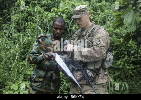 Ghana Streitkräfte Sgt. Francis Kofi Donkor Bewertungen seine Position auf einer Karte mit US-Armee 2. Lt. Hugh Smith zum 1.BATAILLON zugeordnet, 506Th Infantry Regiment, 1st Brigade Combat Team, Luftlandedivision bei United Accord 2017 Jungle Warfare School auf Achiase Militärbasis, Akim Oda, Ghana, 26. Mai 2017. Die Jungle Warfare School ist eine Reihe von situativen Übungen entwickelt, die Teilnehmer in die Train-Aufstand und die innere Sicherheit. Stockfoto