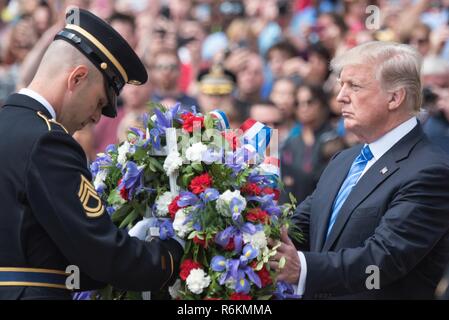 Us-Armee Sgt. 1. Klasse Paul Basso, 3d-Infanterie Regiment (Die Alte Garde) Sgt der Wache, unterstützt Präsident Donald J. Trumpf einen Kranz während der Präsidentschaftswahlen Streitkräfte Ehre Wreath-Laying Zeremonie am Grab des Unbekannten Soldaten auf dem Arlington National Cemetery, 29. Mai 2017. Senior Leadership aus der ganzen DoD gesammelt zu Ehren Amerikas militärische Service Mitglieder gefallen. Stockfoto