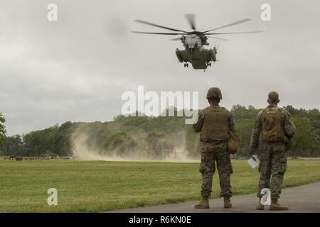 Marines zusehen, wie ein CH-53 Super Hengst cargo Hubschrauber landet auf einem Feld bei einem Memorial Day Zeremonie in New Rochelle, New York, 29. Mai 2017. Marines, Matrosen und Küstenwache sind in New York mit der Öffentlichkeit zu kommunizieren, sich Fähigkeiten demonstrieren und die Leute von New York über America's Meer Dienstleistungen unterrichten. Stockfoto
