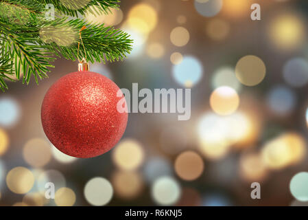 Weihnachten glänzende Kugel am Baum und Weihnachtsbeleuchtung, Bokeh im Hintergrund. Freier Speicherplatz für die Begrüßung von Text. Stockfoto