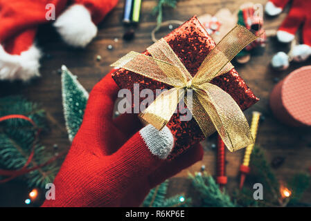 Hand mit Weihnachtsgeschenk verpackt in einer Box für fröhliche Feiertage Stockfoto