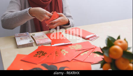 Frau Geld in die roten Paket zum chinesischen Neujahrsfest Stockfoto