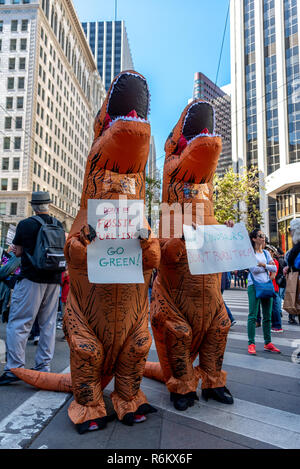 San Francisco, Kalifornien, USA. 8. September 2018. Tausende versammeln sich in San Francisco im Aufstieg für Klima Rally und März im Vorfeld der globalen Klimapolitik Gipfel es September 12. bis 14. stattfinden. Zwei Demonstranten tragen T-Rex Dinosaurier Kostüme und halten Sie Schildern mit der Aufschrift 'Don't fossilen feul-ish. Go Green!' und 'Dig Dinosaurier. Sie nicht brennen." Stockfoto