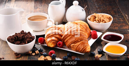 Frühstück serviert mit Kaffee, Croissants, Müsli und Obst Stockfoto