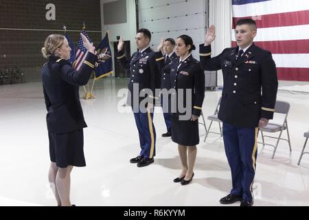 Maj. Barbara Coe, der taktische Offizier und Kommandant der pre-OCS-Programm mit den 207 Dokumentenportal Training Regiment, verwaltet den Amtseid auf Officer Kandidaten Ivan Cuevas, Marisa Lindsay, und David Notti während einer Inbetriebnahme Zeremonie an der National Guard Armory auf gemeinsamer Basis Elmendorf-Richardson, Alaska, 21. Mai 2017. Oberstleutnant Wayne Don, Kommandant der 38th Truppe Befehl war der Gastredner für die Zeremonie. Stockfoto