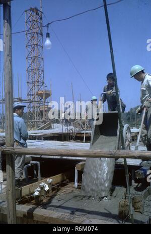 Arbeitnehmer Beton gießt, während das Fundament eines Gebäudes auf einer Baustelle in Japan, 1960. () Stockfoto