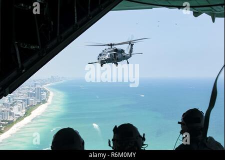 Das bodenpersonal mit Die 129 Rettung Flügel, aus Moffett Federal Airfield, Calif., sehen Sie sich ein HH-60G Pave Hawk von der Rückseite eines HC-130 P/N Kampf gegen König während der Nationalen begrüssen zu Amerikas Helden in der Luft und auf See Medien anzeigen Tag 26. Mai 2017 in Miami Beach, Fla. top tier militärischen US-Vermögenswerte in Miami zu Showcase Luftüberlegenheit zusammengebaut haben beim ehren diejenigen, die das ultimative Opfer während des Memorial Day Wochenende gemacht haben. Die 129 RQW mit zwei HH-60G Pave Hawk und vier A-10 Thunderbolt II Flugzeuge aus der Rettung 920th Wing und dem 442 d Fighter Wing beziehungsweise zu Schlagzeile die Stockfoto