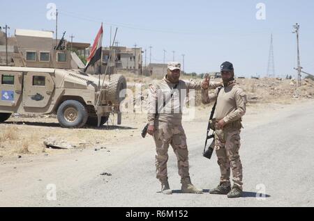 Irakische Armee Soldaten posieren für ein Foto nach der Begrüßung einen Konvoi von Koalitionstruppen in Mossul, Irak, 25. Mai 2017. Mehr als 60 Koalitionspartner haben sich auf das Ziel der Beseitigung der Bedrohung, die von ISIS im Irak und in Syrien stellten verpflichtet und haben in verschiedenen Kapazitäten an der Bemühung beigetragen. CJTF-OIR ist die globale Koalition zu besiegen ISIS im Irak und in Syrien. Stockfoto