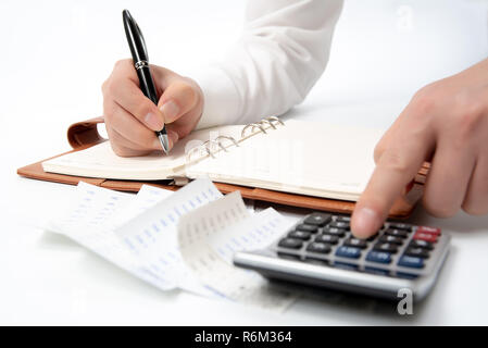 Hände der Unternehmer schriftlich eine Quittung auf einem Notebook, close-up. Stockfoto