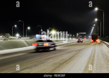 Blick auf die im Winter schneebedeckten Straße mit Feuer vom rauschenden Autos Stockfoto