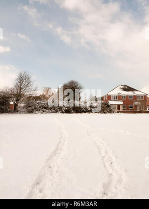 Feld im Schnee mit zwei Spuren durch IT-Landschaft abgedeckt Stockfoto