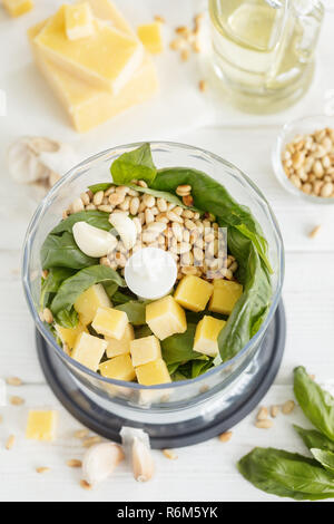 Zutaten für Basilikum Pesto Sauce mischen Blender bowl auf weißem Hintergrund, vertikale Zusammensetzung Stockfoto